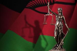 malawi bandiera con statua di signora giustizia e giudiziario bilancia nel buio camera. concetto di giudizio e punizione foto