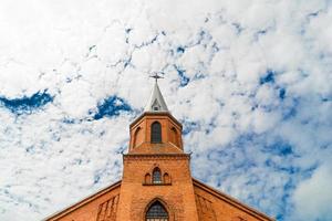 vecchio Chiesa su il sfondo di blu cielo e bianca nuvole foto