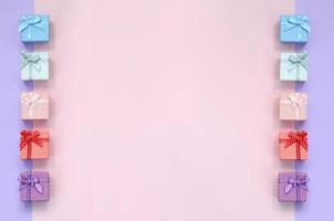 piccolo regalo scatole di diverso colori con nastri bugie su un' viola e rosa colore sfondo foto