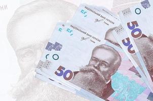 50 ucraino grivna fatture bugie nel pila su sfondo di grande semi trasparente banconota. astratto presentazione di nazionale moneta foto