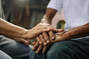 mani di il vecchio uomo e un' donna mano su il legna tavolo foto