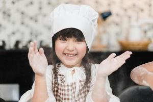 gruppo di bambini cottura al forno torta insieme nel aula, multietnico giovane ragazzi e ragazze contento fabbricazione dolce cucinando nel cucina a scuola. bambini cucinando a scuola concetto. foto