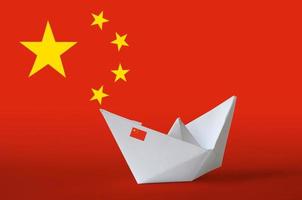 Cina bandiera raffigurato su carta origami nave avvicinamento. fatto a mano arti concetto foto
