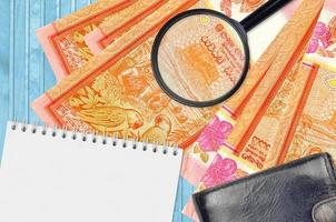 100 sri lanka rupie fatture e ingrandimento bicchiere con nero borsa e bloc notes. concetto di contraffazione i soldi. ricerca per differenze nel dettagli su i soldi fatture per individuare falso foto