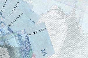 5 ucraino grivna fatture bugie nel pila su sfondo di grande semi trasparente banconota. astratto attività commerciale sfondo foto