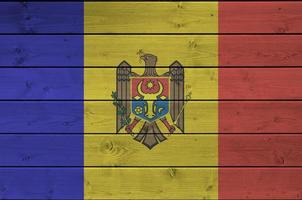 moldova bandiera raffigurato nel luminosa dipingere colori su vecchio di legno parete. strutturato bandiera su ruvido sfondo foto