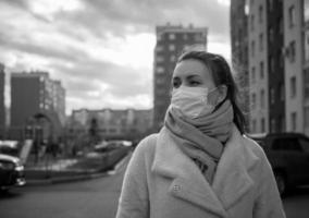scatto di una ragazza in maschera, per strada. pandemia di covid-19 di blocco. foto