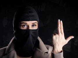 ritratto di un' ragazza nel un' nero Balaclava e beige cappotto. foto