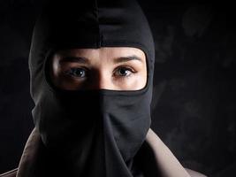 ritratto di un' ragazza nel un' nero Balaclava e beige cappotto. foto