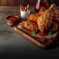 croccante fritte pollo su un' di legno piatto con pomodoro salsa foto