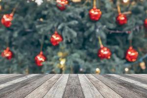 vuoto legna tavolo superiore con sfocatura Natale albero con bokeh leggero sfondo foto