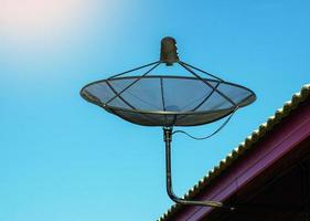 satellitare piatto installato su il tetto di il Casa per ricevente televisione onde. morbido e selettivo messa a fuoco. foto