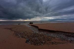 pietre su il costa di il baltico mare a tramonto foto