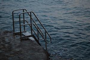 ringhiera a il spiaggia, metallo ringhiera nel il acqua, foto