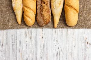 appena al forno francese baguettes su bianca di legno tavolo. superiore Visualizza, copia spazio foto