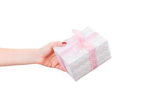 donna mani dare avvolto Natale o altro vacanza fatto a mano presente nel colorato carta con rosa nastro. isolato su bianca sfondo, superiore Visualizza. ringraziamento regalo scatola concetto foto