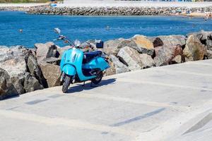 motociclo vicino mare costa. scooter parcheggiata vicino il spiaggia. foto