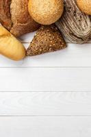 assortimento di fresco pane su un' bianca di legno sfondo. superiore Visualizza con copia spazio foto