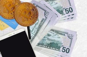 50 noi dollari fatture e d'oro bitcoin con smartphone e credito carte. criptovaluta investimento concetto. crypto estrazione o commercio foto