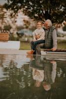 nonno la spesa tempo con il suo nipotina di piccolo acqua piscina nel parco su autunno giorno foto