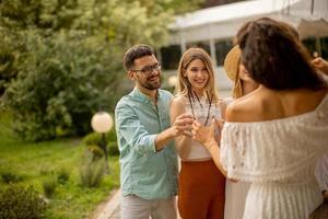 gruppo di contento giovane persone applauso con fresco limonata nel il giardino foto