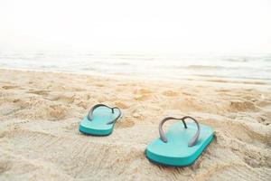 mare su il spiaggia orma persone su il sabbia e pantofola di piedi nel sandali scarpe su spiaggia sabbie sfondo. viaggio vacanze concetto. foto