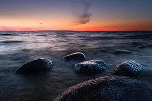 pietre su il costa di il baltico mare a tramonto foto