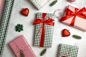 superiore Visualizza su tavolo con Natale regali, confezioni carta e altro decorazioni. vacanze piatto posare nel rosso bianco e verde colori foto