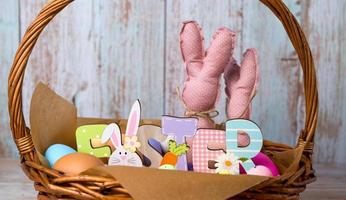 avvicinamento di Pasqua cestino con colorato uova, giocattolo bannie anf Pasqua di legno segno.aprile vacanze foto