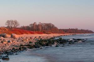 pietre su il costa di il baltico mare a tramonto foto