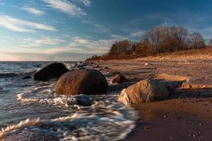 pietre su il costa di il baltico mare a tramonto foto