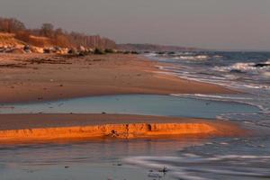 pietre su il costa di il baltico mare a tramonto foto