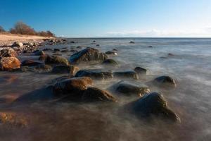 pietre su il costa di il baltico mare a tramonto foto