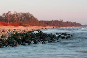 pietre su il costa di il baltico mare a tramonto foto