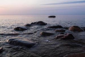 pietre su il costa di il baltico mare a tramonto foto