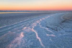 baltico mare costa con ciottoli e ghiaccio a tramonto foto