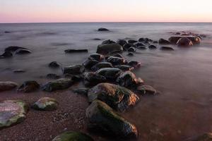 pietre su il costa di il baltico mare a tramonto foto