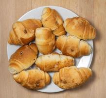 molti piccolo Cornetti su un' bianca sfondo. Cornetti con bollito condensato latte. confetteria nel il cucina. foto