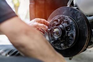 vicino su disco di freno tecnico dai un'occhiata guidare albero e Grasso nel cuscinetto alloggiamento di ruota servizio controllo il Manutenzione periodo di auto per sicurezza nel viaggio foto