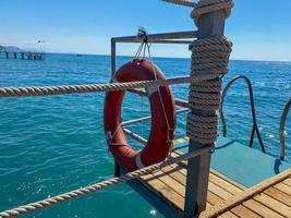 il giro non affondante rosso salvagente per sicurezza per Salva il vite di annegamento persone turisti contro il sfondo di il mare nel un' caldo orientale tropicale nazione meridionale Paradiso ricorrere foto