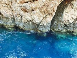 il blu mare battiti onde contro il roccia. montagna su il costa. vacanze nel caldo Paesi. il struttura di il montagna, il roccia con un' 3d volume foto