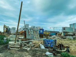 costruzione di un' nuovo quartiere. spazzatura su il luogo, di legno rovinato case per il vita di costruttori. abbellimento di il nuovo la zona foto