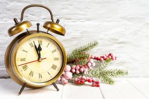 decorativo Natale albero e allarme orologio su bianca mattone parete sfondo. foto