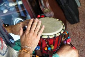 mani di uomo giocando africano tamburo o djembe dentro un' musica negozio. chiang mai, Tailandia. foto