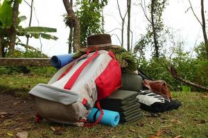 attrezzatura per campeggio su un' erba - zaino, tenda, addormentato borse, stuoie e altro cose per confortevole campeggio vita. foto