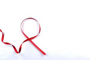 rosso supporto nastro isolato su bianca sfondo. mondo AIDS giorno e nazionale hiv AIDS e invecchiamento consapevolezza mese con rosso nastro. copyspace la zona foto