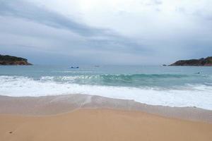 schiuma a partire dal il onde come essi raggiungere il sabbia su il spiaggia foto