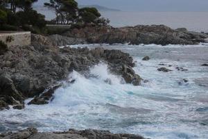 mare raggiungendo il rocce la creazione di spruzzi di schiuma foto