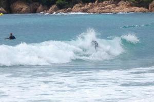 surfers equitazione onde nel un' sballottato dalla tempesta mare foto