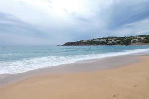 schiuma a partire dal il onde come essi raggiungere il sabbia su il spiaggia foto